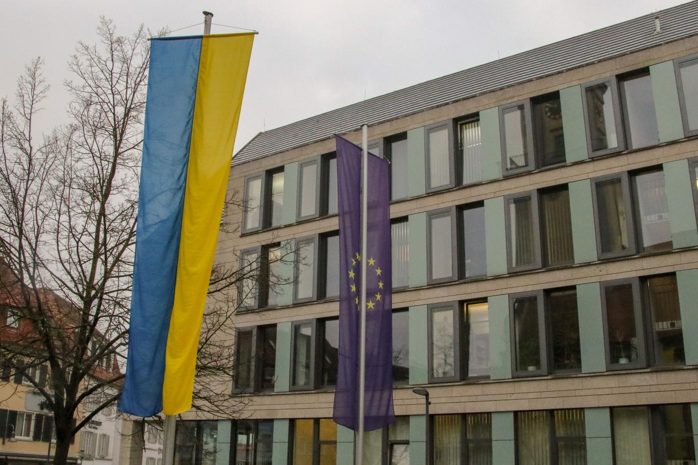 Die blau-gelbe Flagge der Ukraine und die blaue Flagge der EU mit gelbem Sternenkreis.