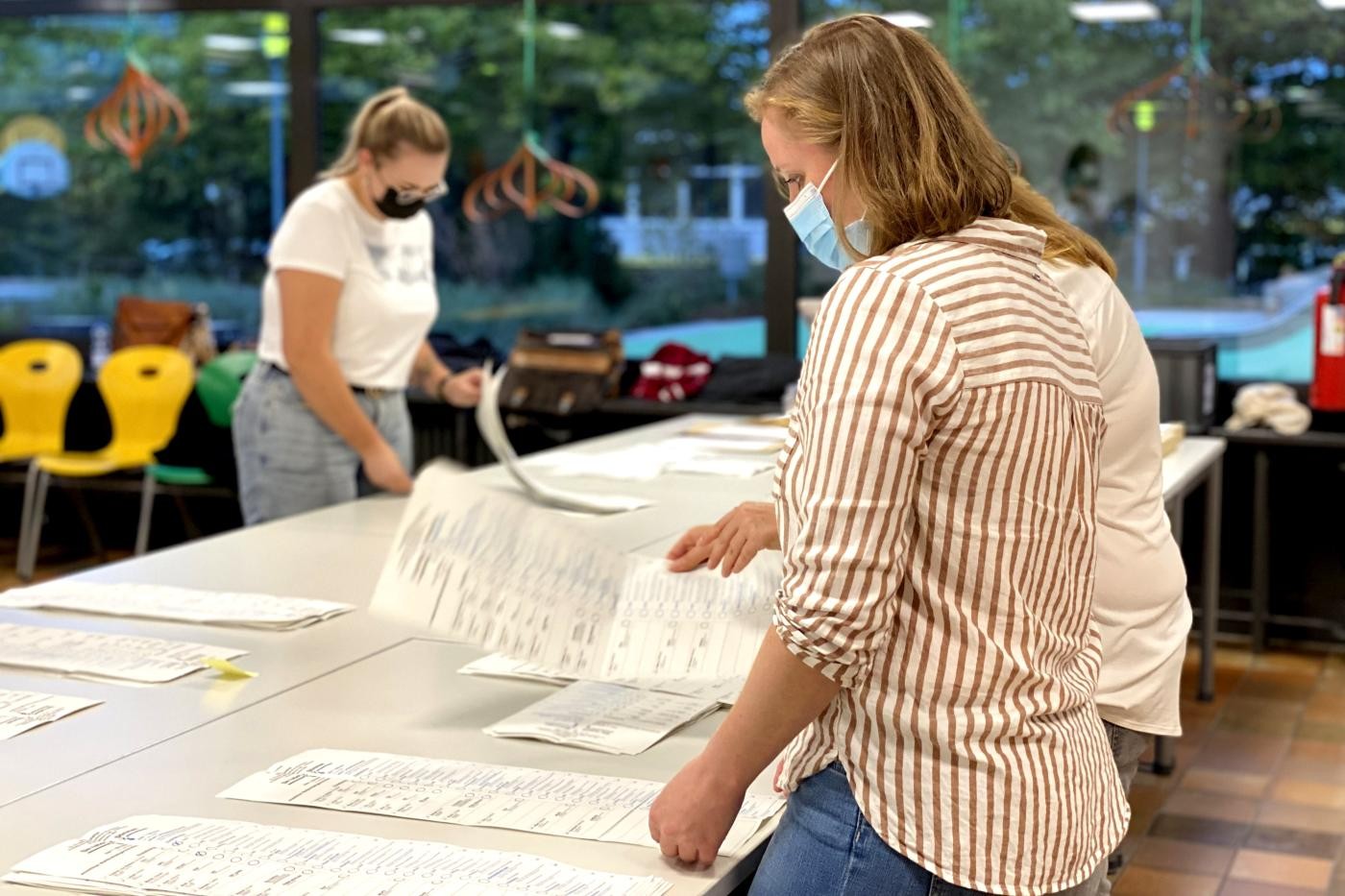 Rathausmitarbeitende zählen die Wahlzettel aus.