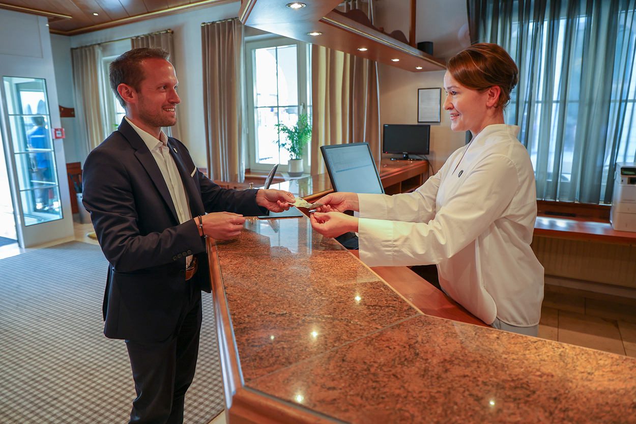 Ein Mann gibt einer Frau hinter einer Theke Geld.