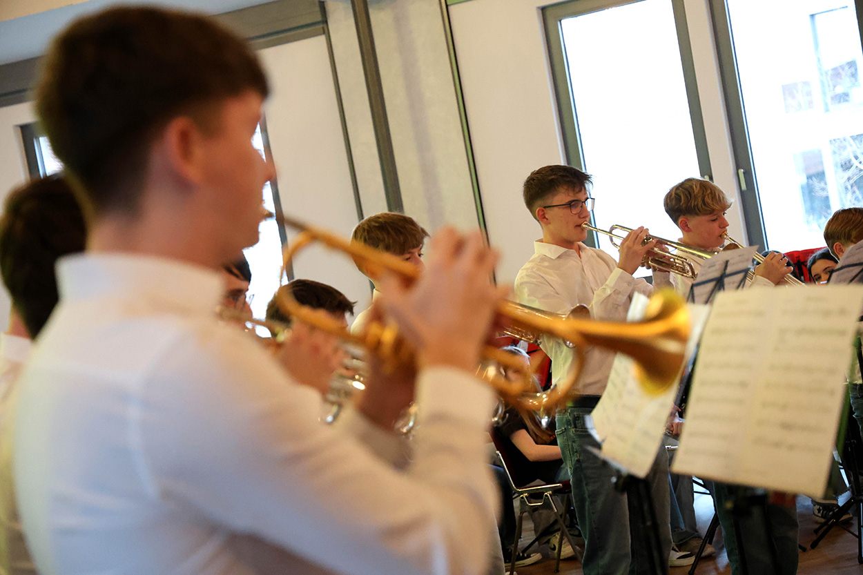 Junge Menschen spielen Blechblasinstrumente