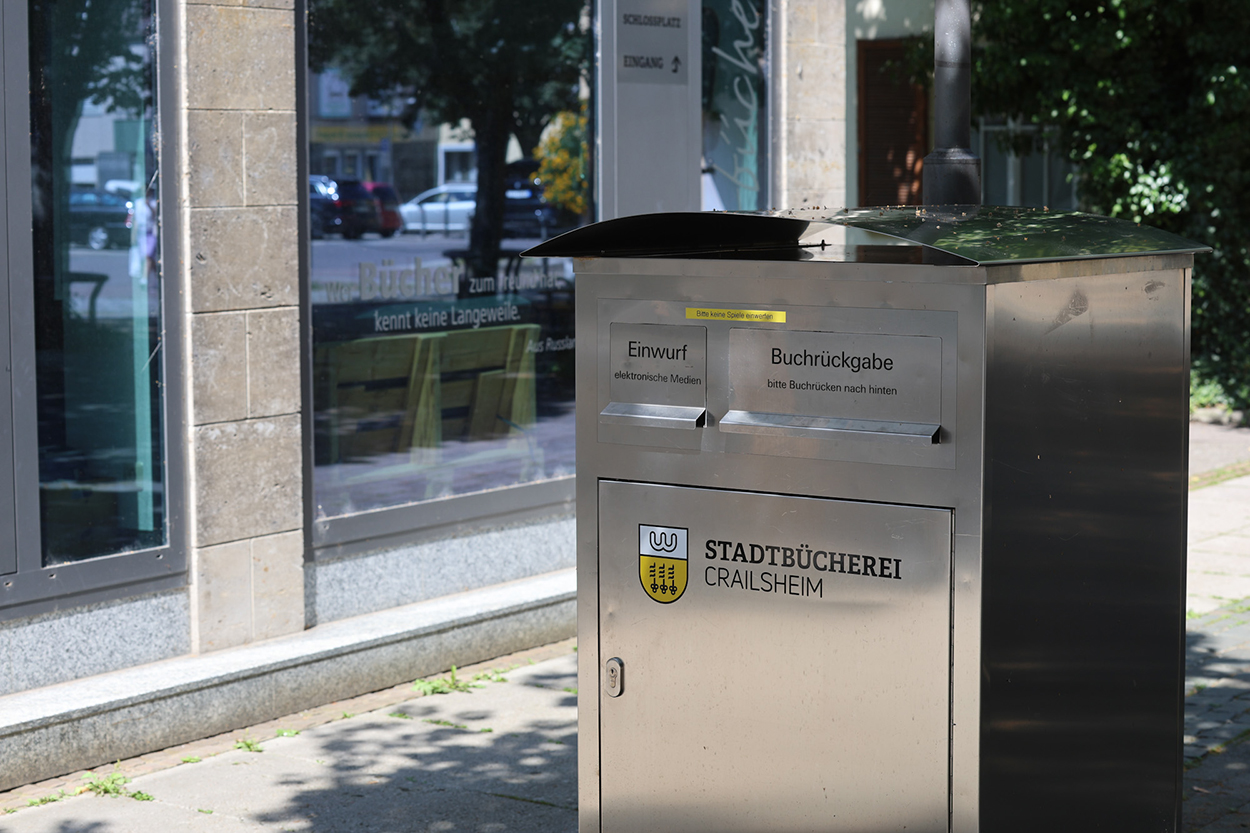 Ein großer silberner Briefkasten vor einem großen Glasfront