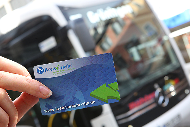 Im Vordergrund ist ein Jobticket und im Hintergrund ein Bus zu sehen.