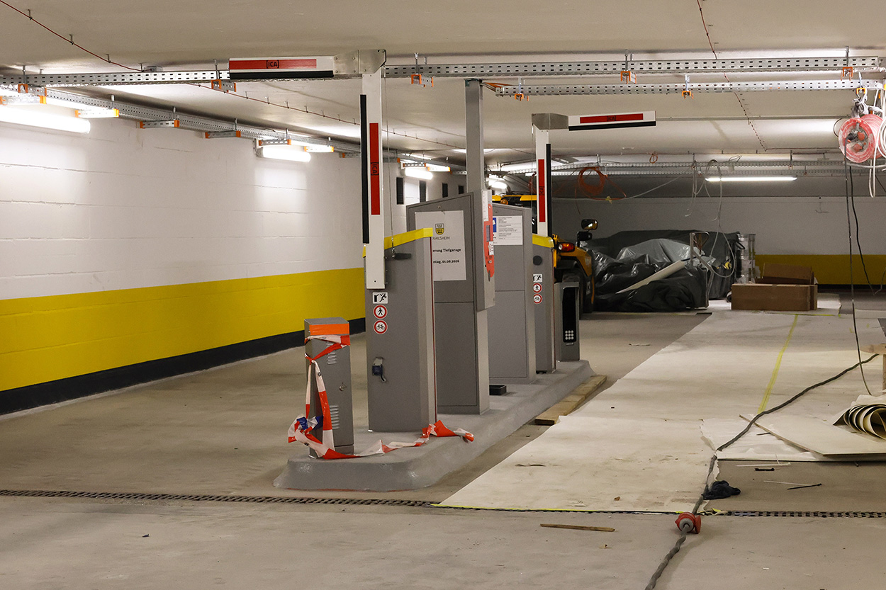 Eine Schrankenanlage in einer Tiefgarage, im Hintergrund Baumaterial