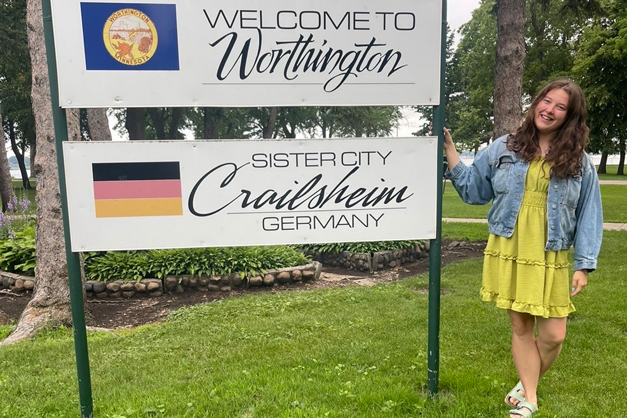 eine jung Frau steht an einer Tafel, die die Städtepartnerschaft Crailsheim-Worthington darstellt