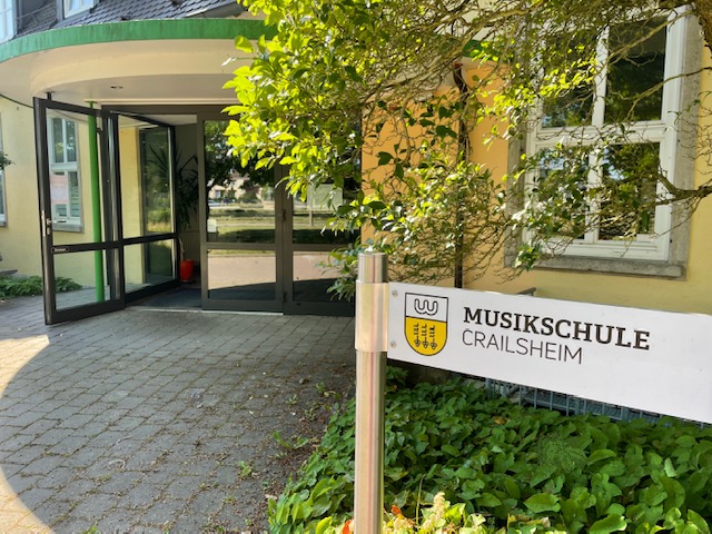 Der Eingang einer Musikschule, worauf ein Schild rechts im Bild hinweist