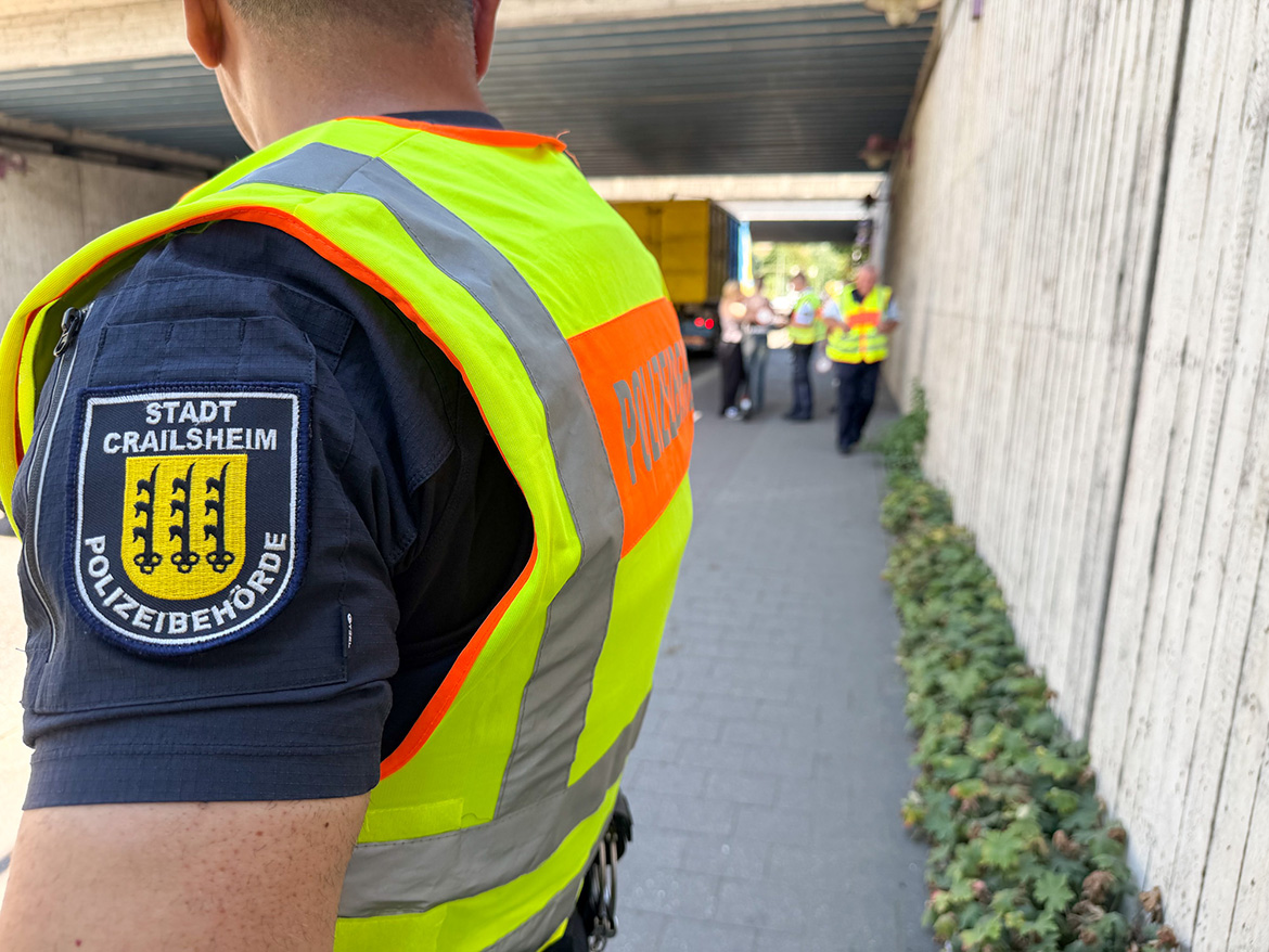 Ein Mitarbeiter des KOD beobachtet einen Kontrolle von E-Scooter-Fahrern