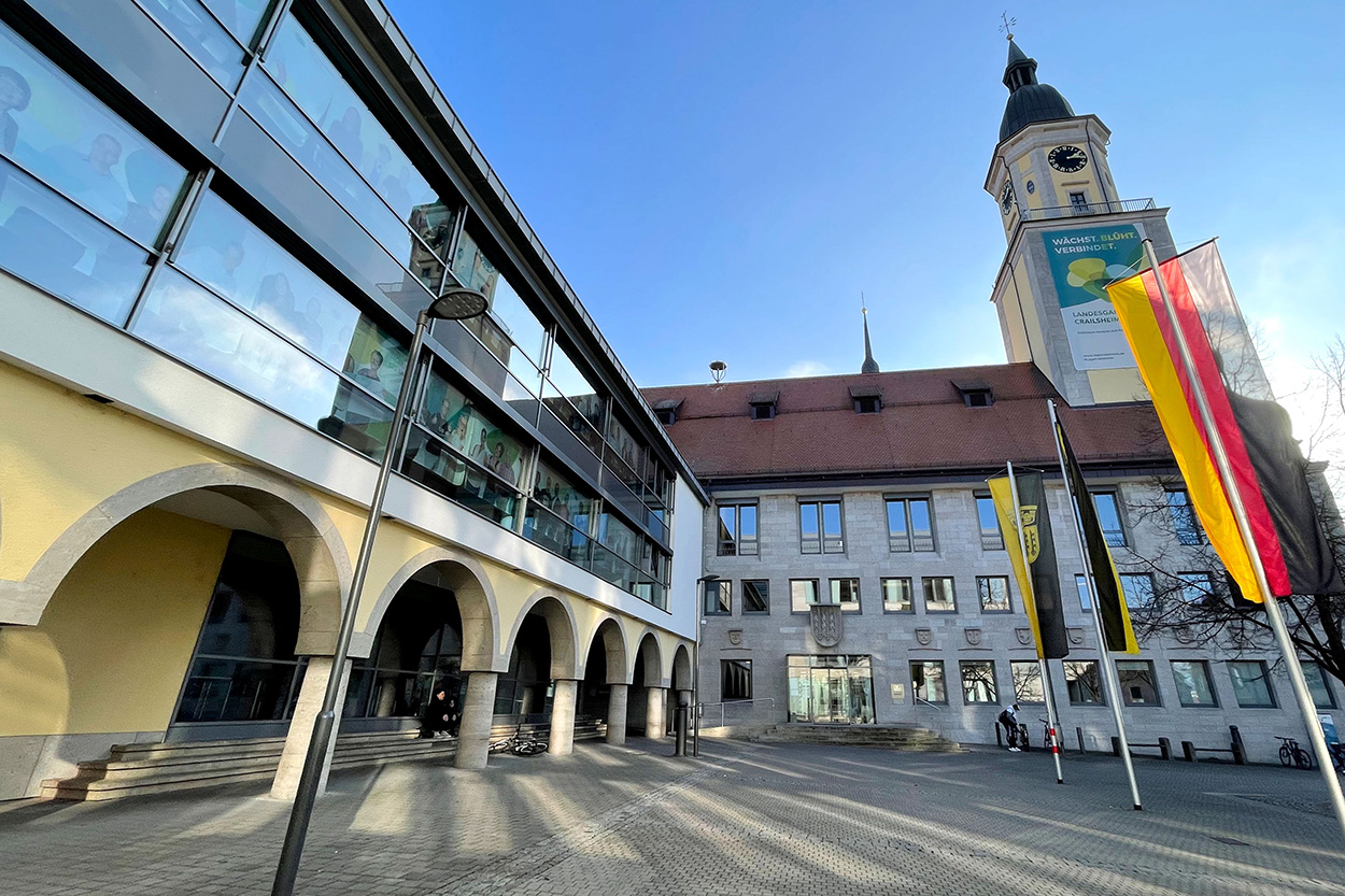 Ein großes Gebäude, teils verglast, mit Turm und ein Innenhof