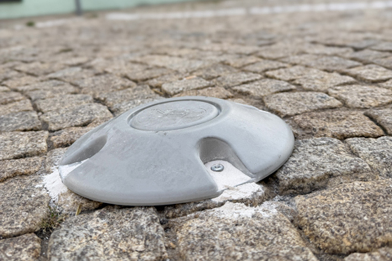 Ein hauben ähnliches Metallteil auf Pflastersteinen