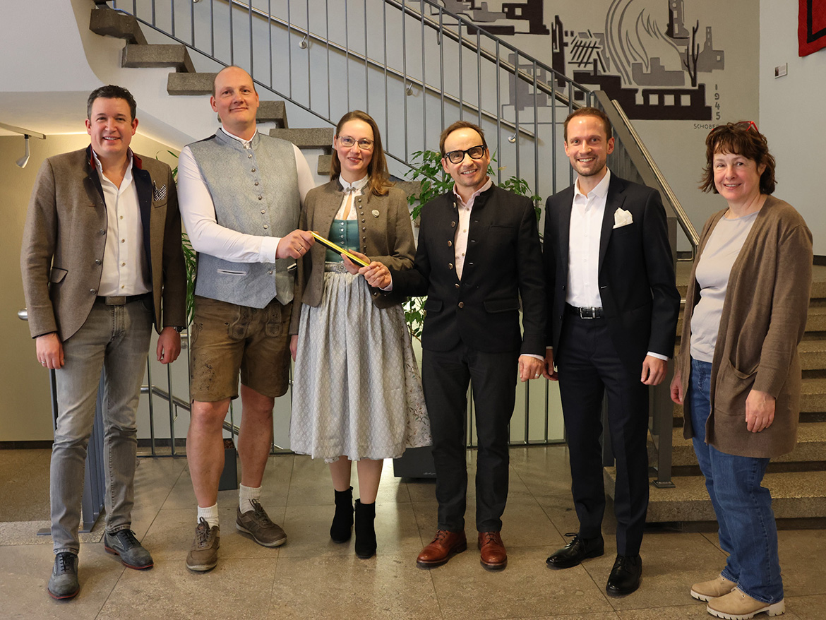 Eine Gruppe Menschen, teils in Tracht, lächelt in die Kamera